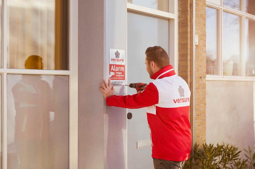 Installatore Verisure mette un cartello dissuasore per prevenire furti in casa