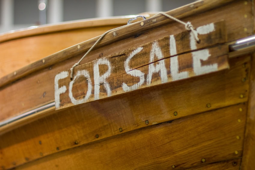 Holzboot mit der Aufschrift For Sale Der Bug eines Holzbootes von der Seite, mit der Aufschrift "For Sale"