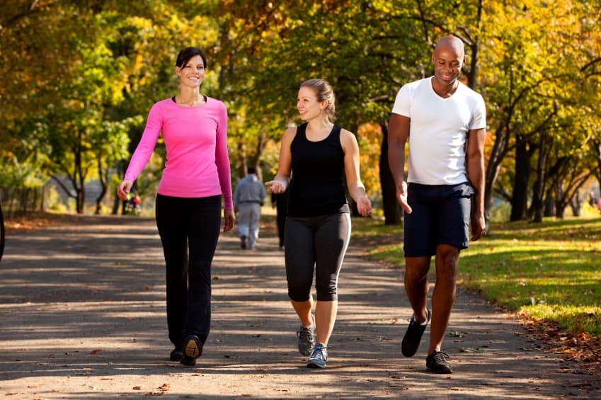 Three people walking in a park