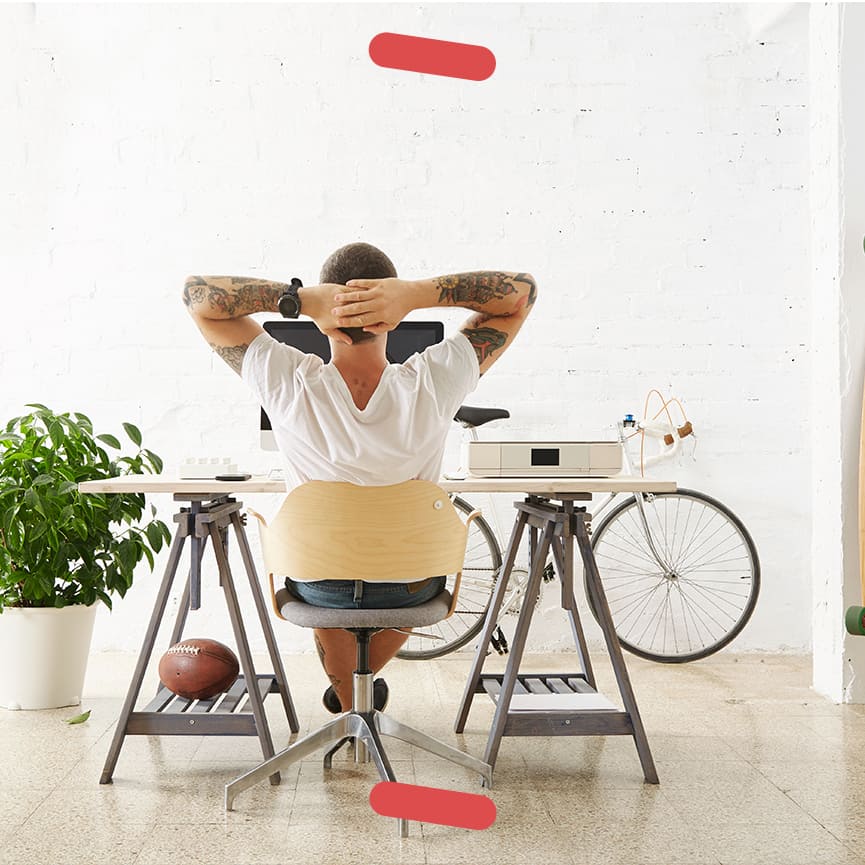 Man at desk with hands folded behind head