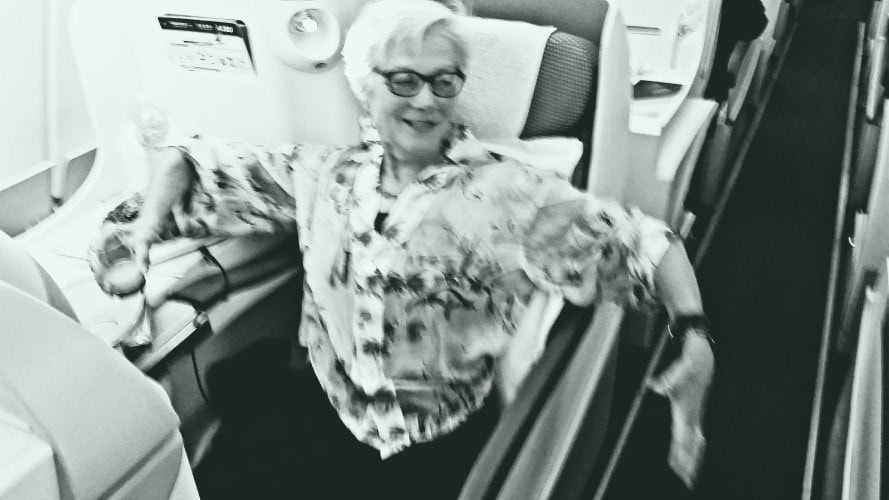 Unstoppable Stacey in Business Class seat with arms spread to show how much room she has in the width of her China Southern seat.