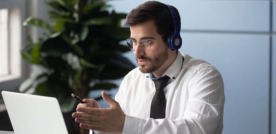 Businessman in headphones makes videocall chatting with partner consulting client