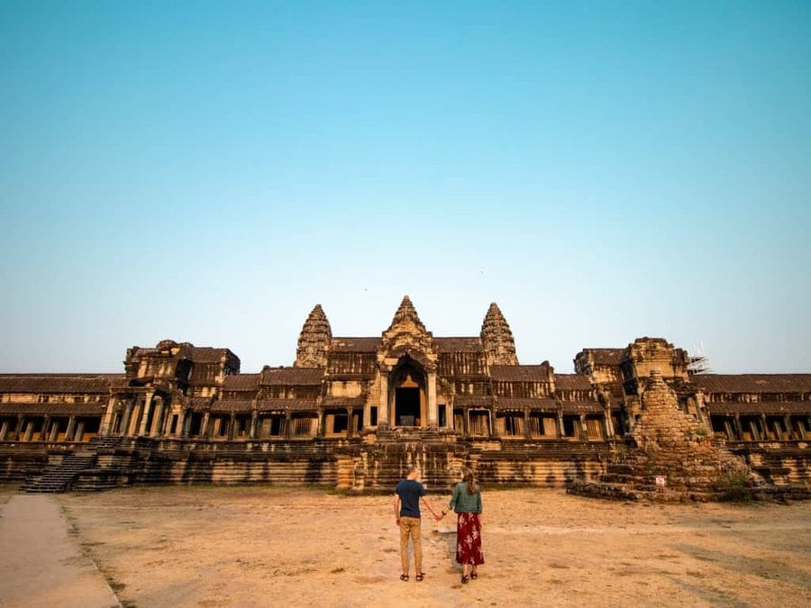 Couple looking up at Angkor Wat temple