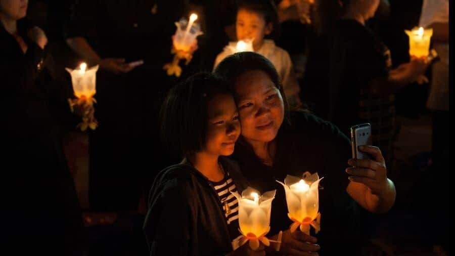 Exciting Places to Spend NYE - FlightGurus.com Bangkok Thailand Thai people light candles and give prayers as they mark New Years Eve.