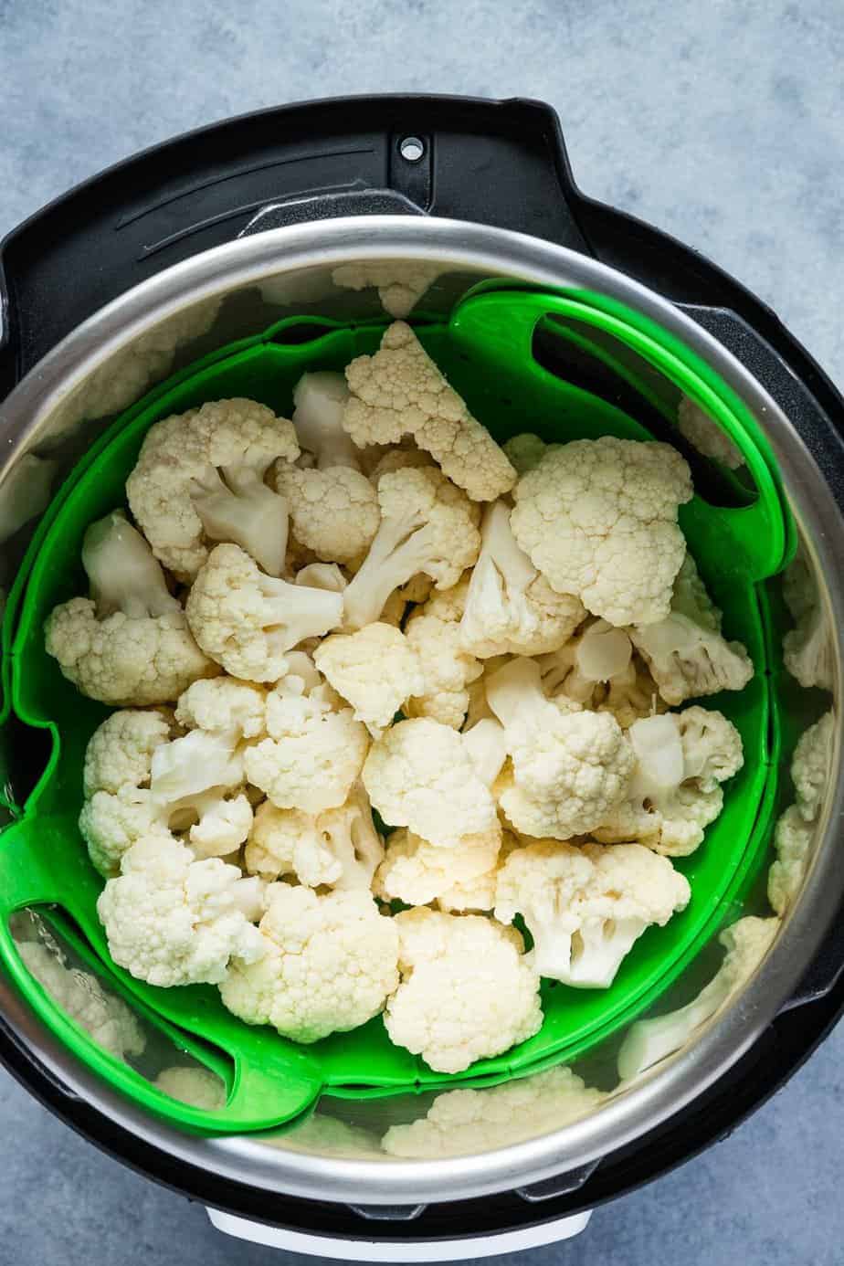 cauliflower florets in the steamer basket inside the instant pot