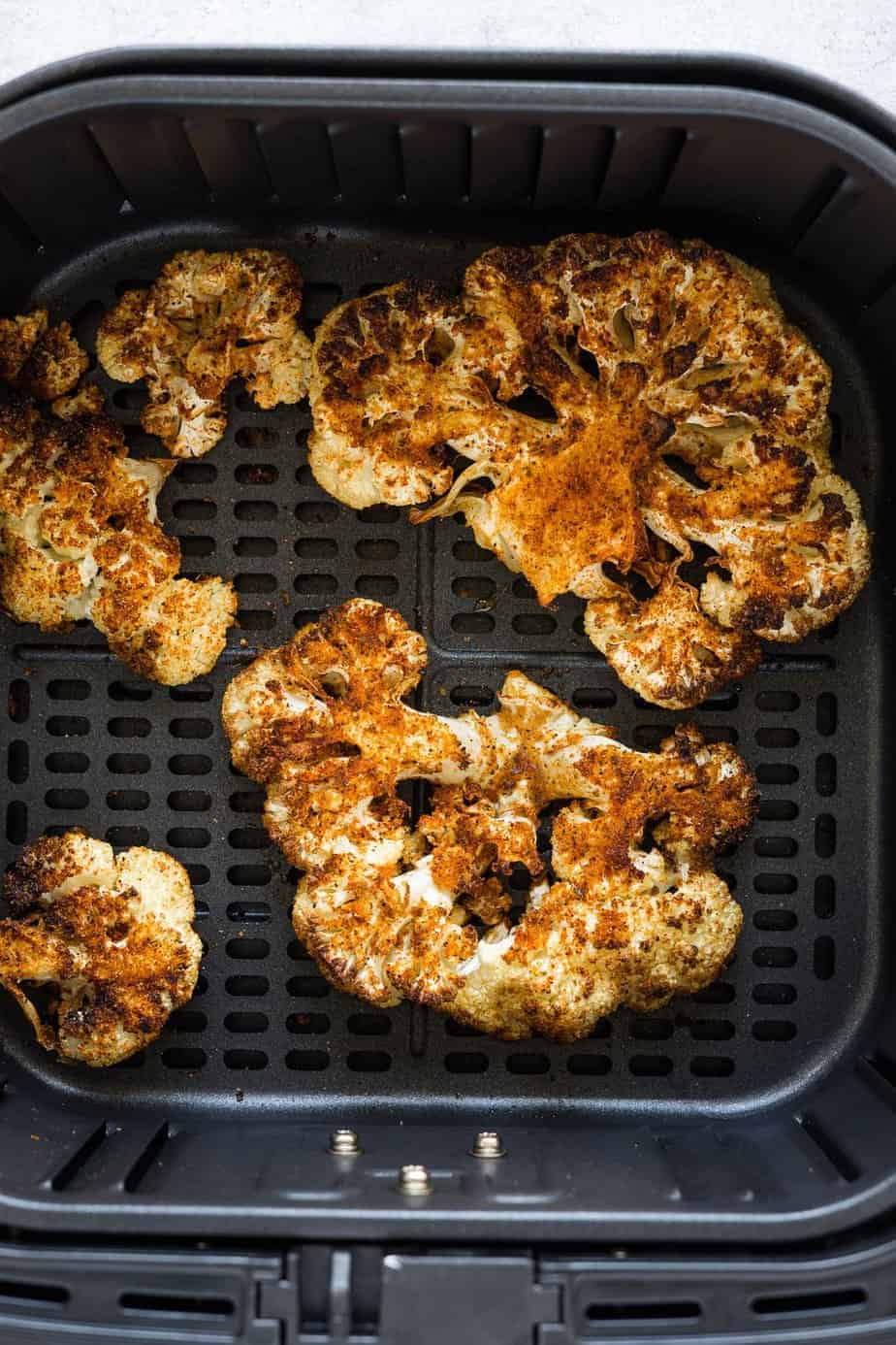 steaks inside the air fryer basket after cooking.