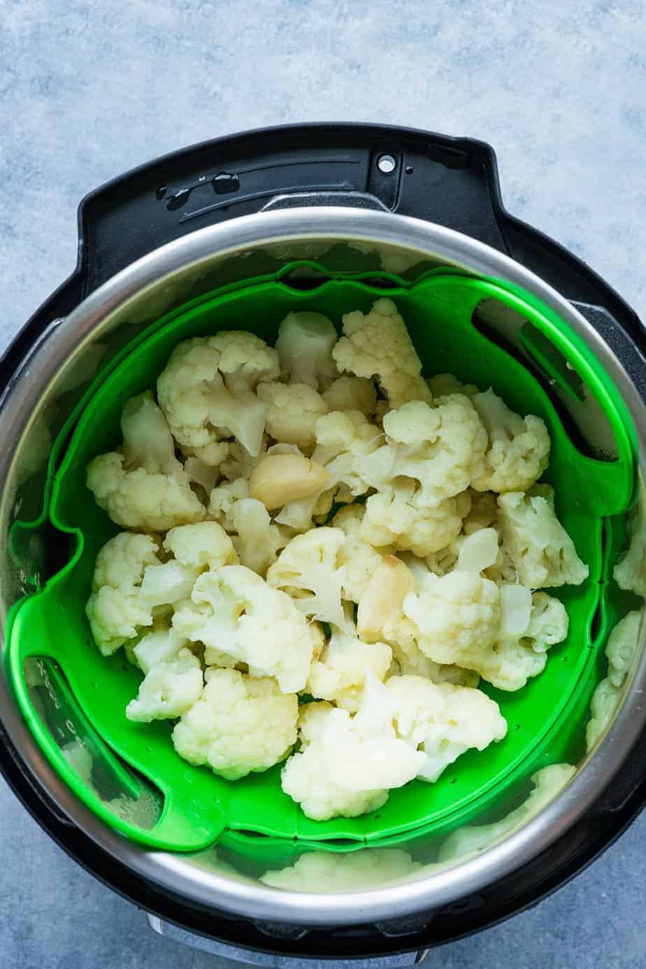 cauliflower florets and garlic cloves inside the instant pot after pressure cooking.