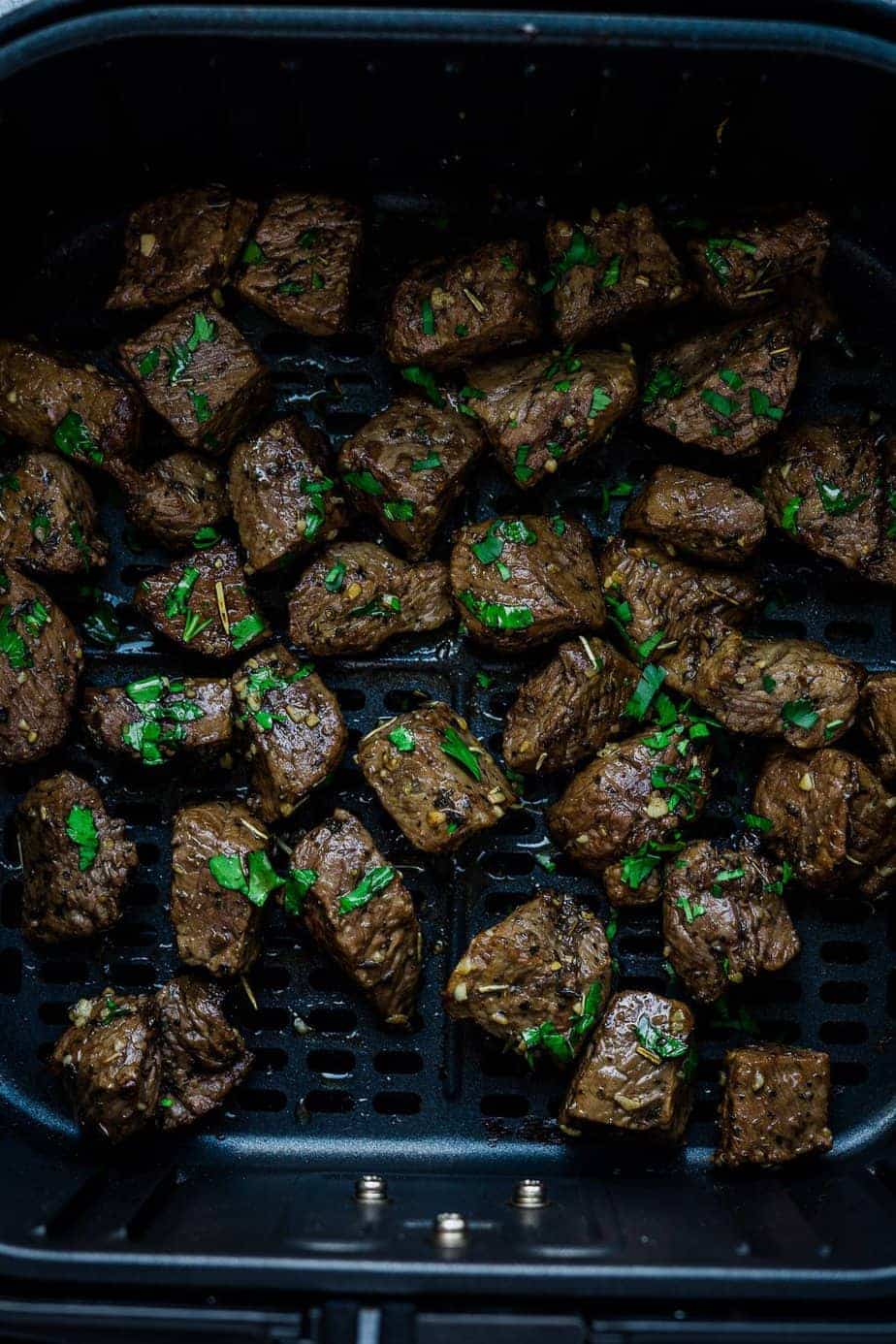appetizer of beef pieces garnished with fresh parsley.