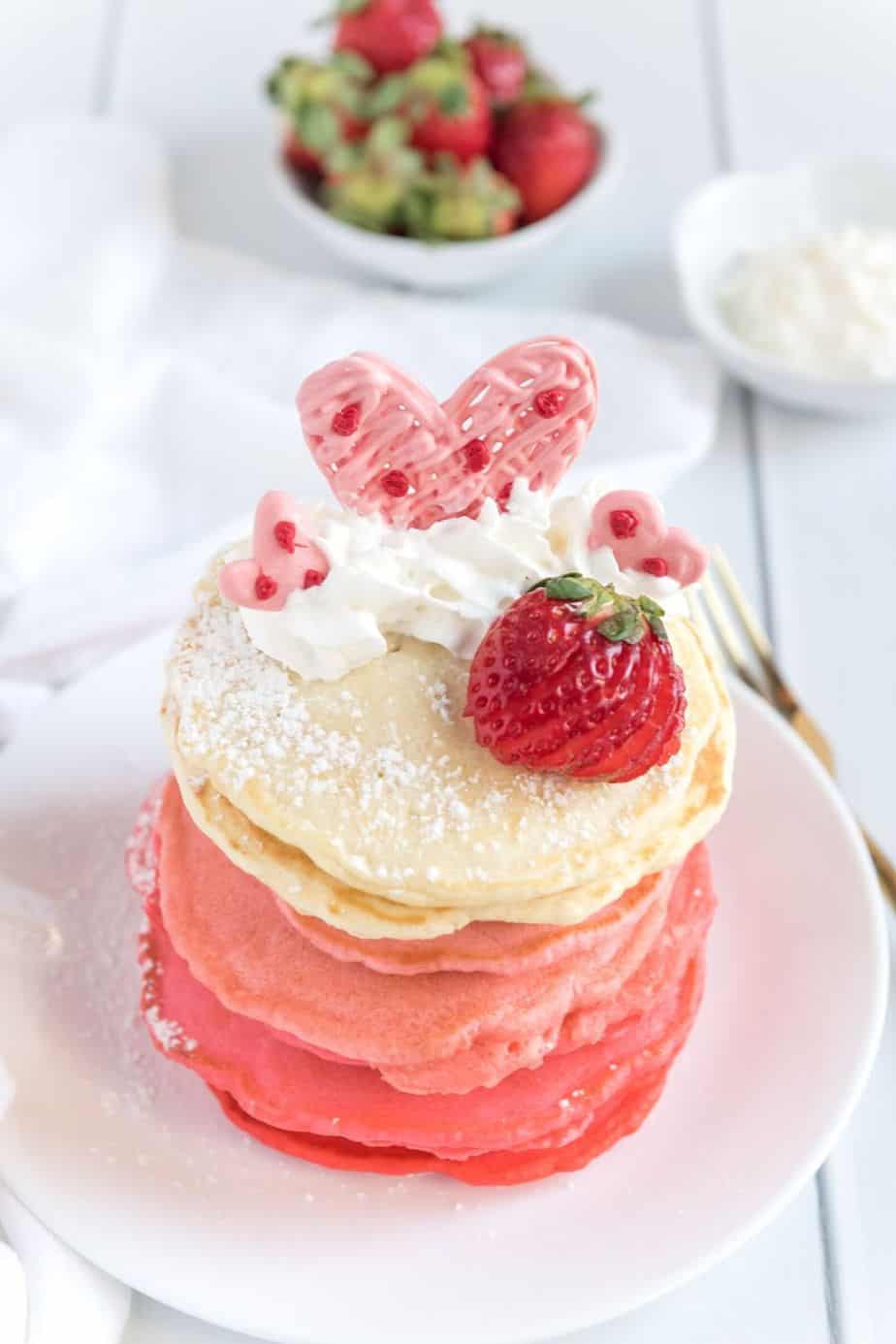 These Pink Ombre Pancakes are the perfect homemade Valentine's Day Pancake Recipe. Your family will love these light and fluffy pancakes. Share some love and make easy pancake recipe can be served all year long. #valentinesdaypancakes #ombrepancakes