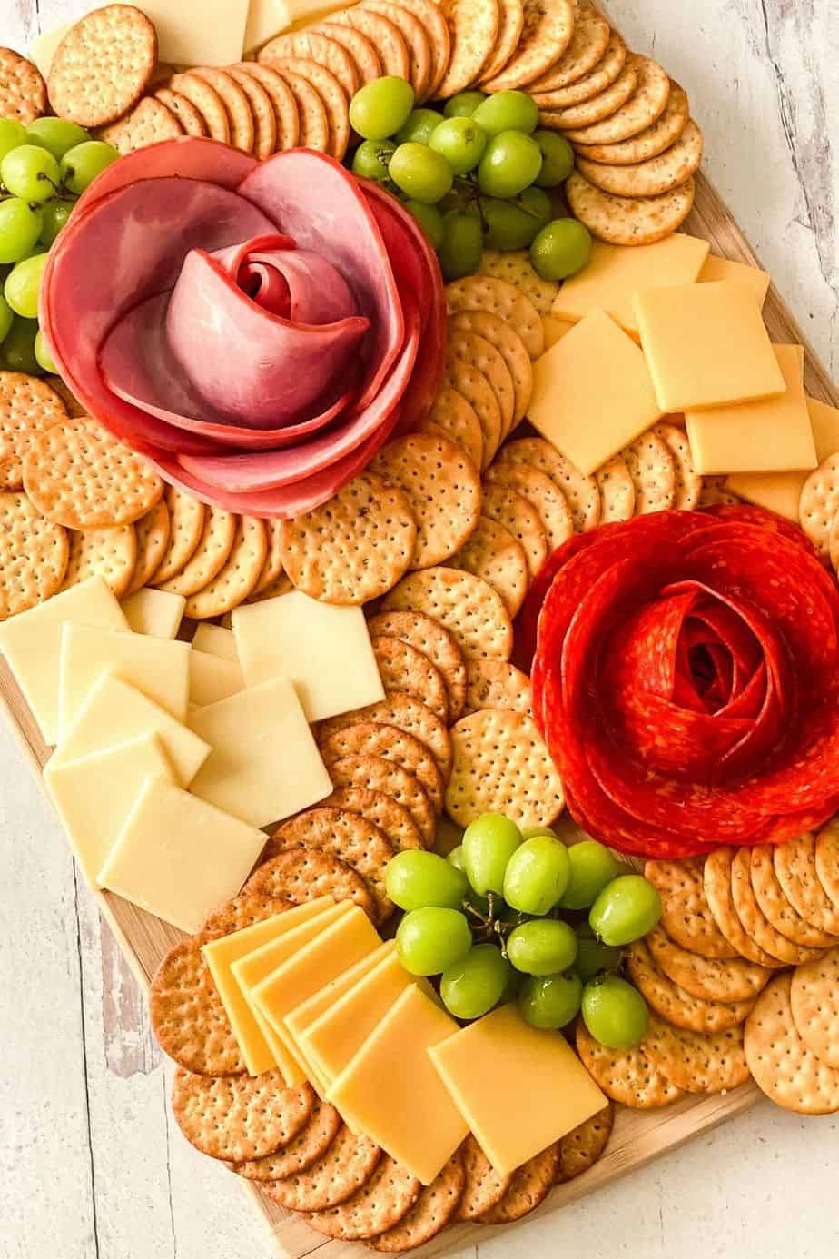 Dazzle your guests with this easy charcuterie board idea. Learn how to make a Charcuterie Board With Meat Flowers. It looks fancy but these meat flowers are easy to make. This is an easy party idea!