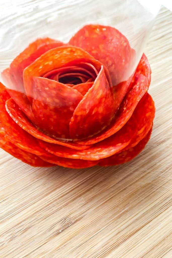 Dazzle your guests with this easy charcuterie board idea. Learn how to make a Charcuterie Board With Meat Flowers. It looks fancy but these meat flowers are easy to make. This is an easy party idea!