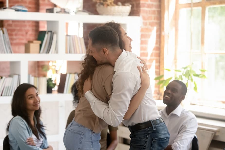 people hugging in a group therapy