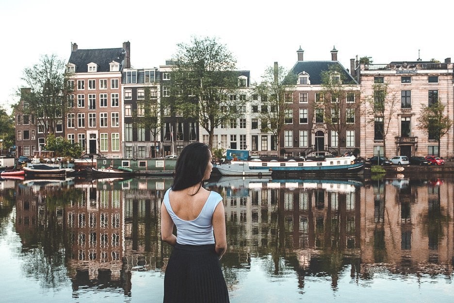 Why You Should Be An Expat At Least Once In Your Life 4 L A woman stands next to a canal in Amsterdam, the Netherlands