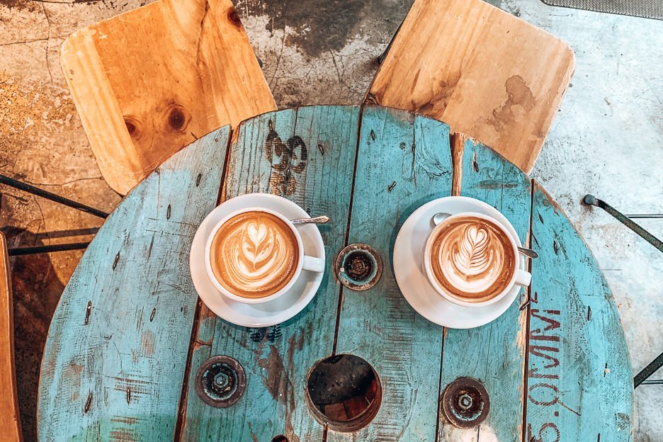 7 Places For Specialty Coffee In Hong Kong 5 L Large flat white and mint mocha on a faded blue wooden table at The Brew Job Coffee, Kowloon, Hong Kong