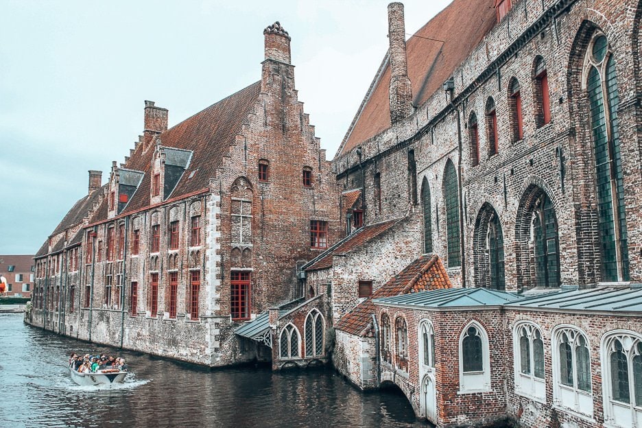 A Complete Guide To 24 Hours In Bruges 2 L A boat on the canal goes by behind museum Sint-Janshospitaal, Bruges Belgium