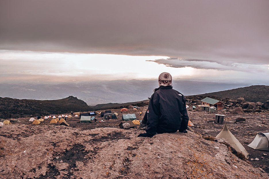 How I Summitted Kilimanjaro The Machame Route In 7 Days 11 L Jasmine sitting on a boulder looking over Barranco camp along the Machame Route - 7 days