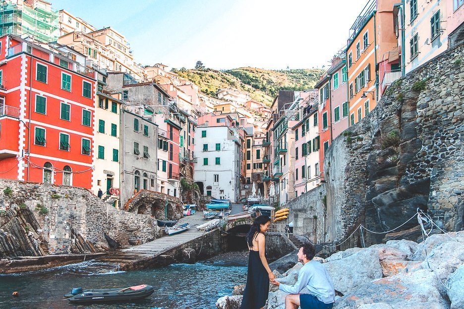 How To Spend 3 Days In Cinque Terre 2 L A couple sit on the rocks in the harbour of RIomagiorre, Cinque Terre, Italy