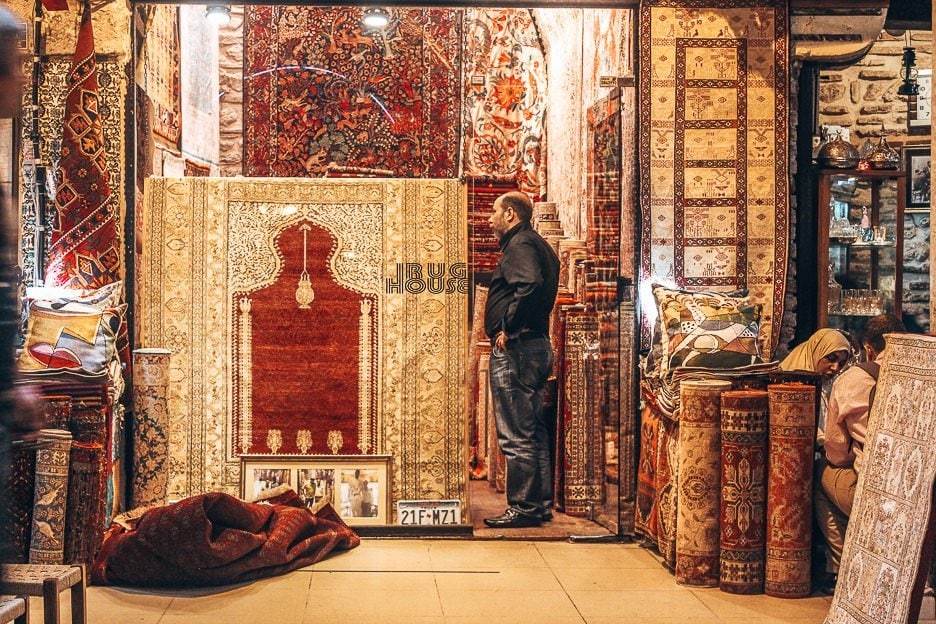 Istanbul A City For the Senses 7 L A man stands at the entrance of his rug shop inside the Grand Bazaar - Istanbul City Guide, Turkey