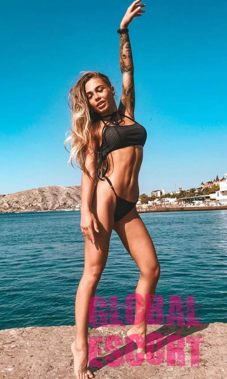 charming model Valeria in a sexy black swimsuit on the pier