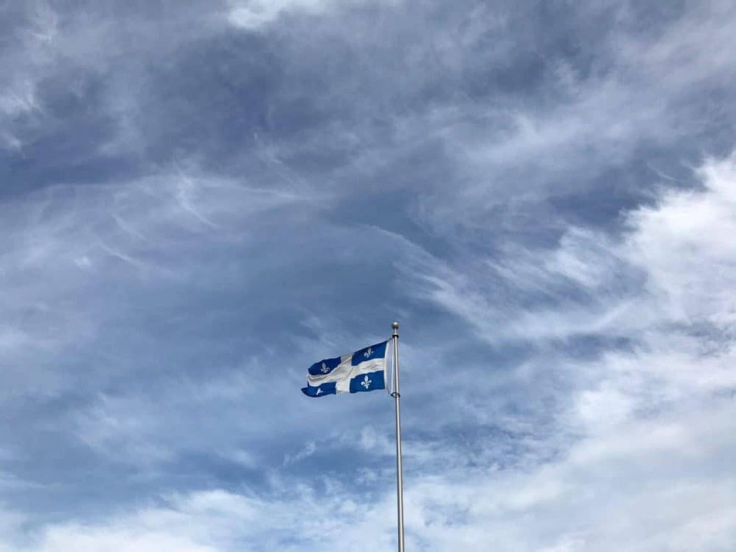 Drapeau Québécois flottant dans le ciel bleu Drapeau du Québec