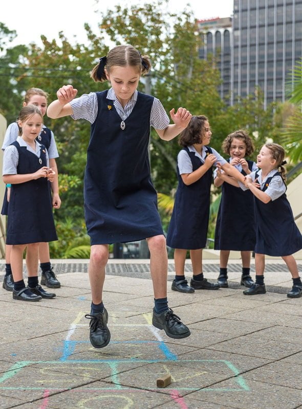 Girls playing hopscotch at school