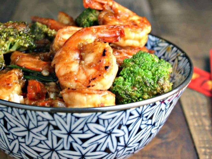 A bowl of food on a table, with Shrimp Broccoli Stir Fry