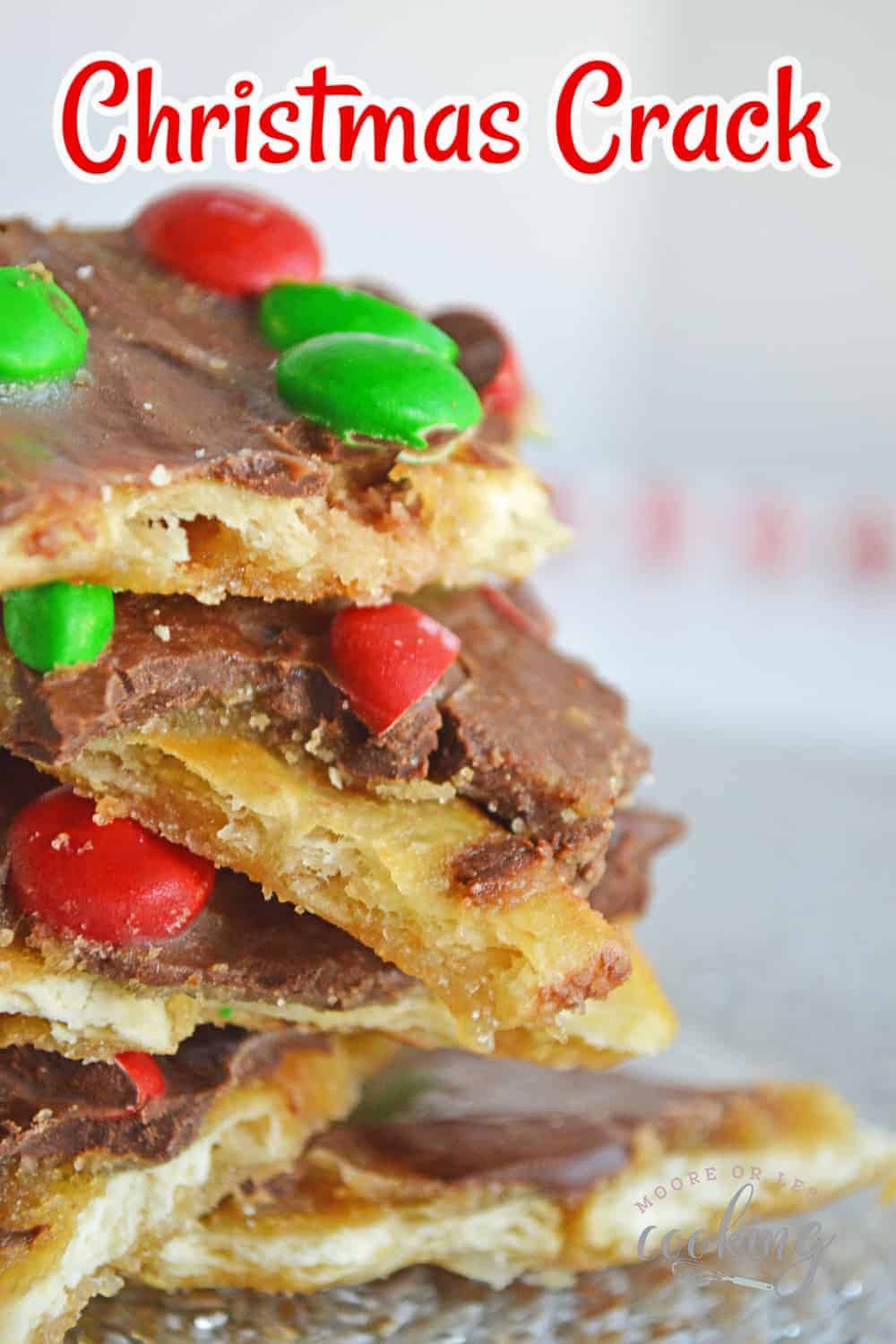 This must-make holiday Christmas Crack sweet treat can be made in just 15 minutes! It’s a tasty combination of sweet and salty plus caramel and chocolate that’s topped with red and green candy-coated chocolate M & Ms for a festive touch. via @Mooreorlesscook
