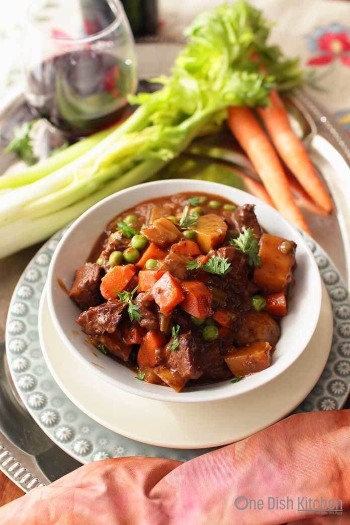 Beef Stew on a tray with carrots and celery | One Dish Kitchen