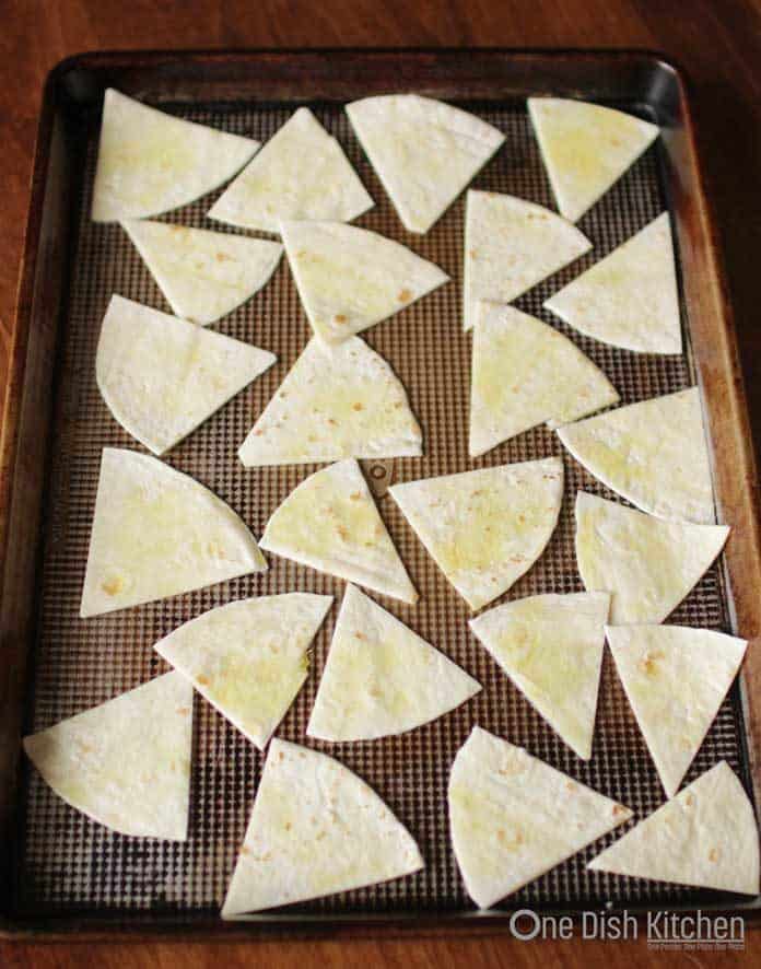 tortilla sliced into wedges on a baking tray ready to go into the oven