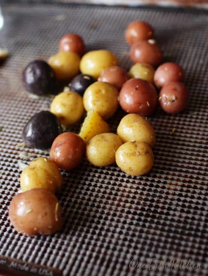 cooked potatoes on a baking sheet before smashing for garlic smashed potatoes | one dish kitchen