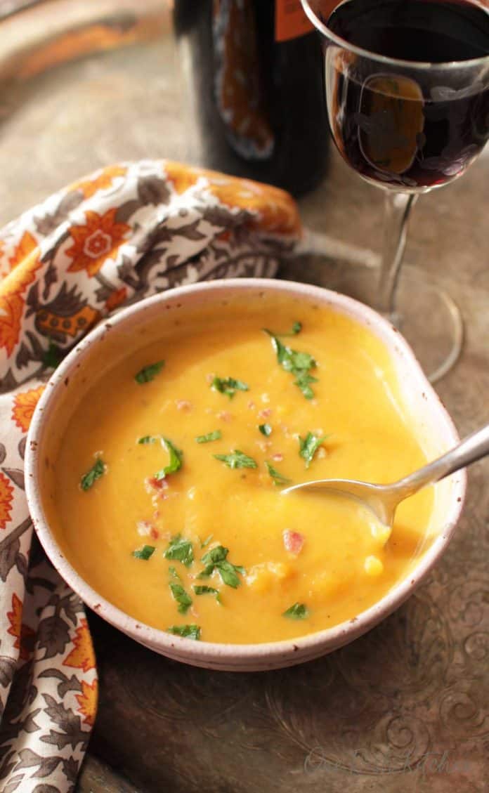 an overhead view of a bowl of butternut squash soup with a spoon which was cooked in an Instant Pot | One Dish Kitchen