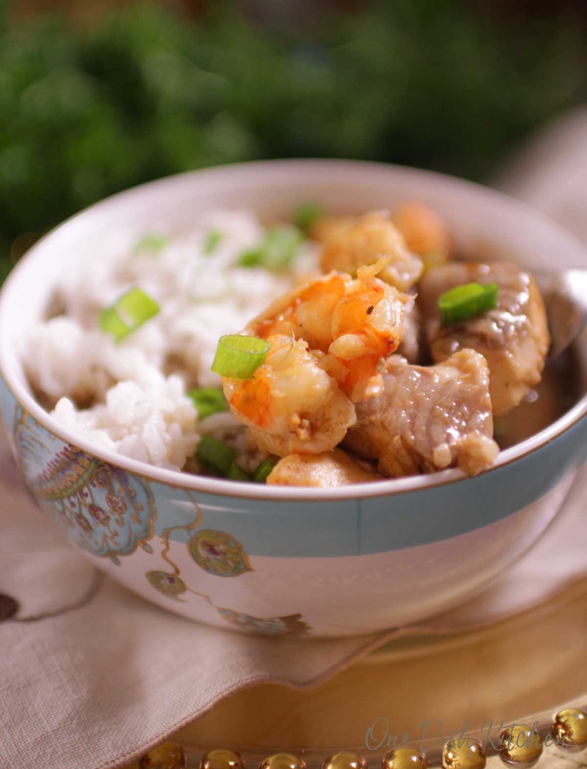a close up picture of gumbo with shrimp and fish in the top of the bowl.