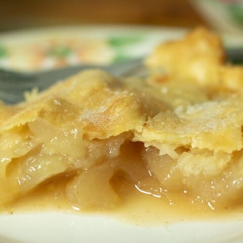 a close up of a slice of apple pie on a plate