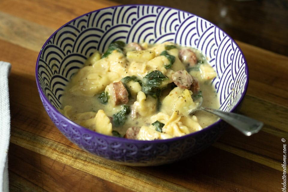 close up of spinach sausage and tortellini soup