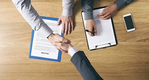 Shaking hands over signed document