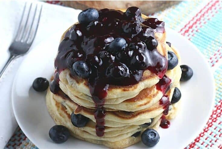 Start your morning off with a delicious batch of Blueberry Buttermilk Pancakes from scratch. This light and fluffy blueberry pancake recipe is perfect for blueberry season or all year round. Top this easy blueberry pancake recipe with homemade blueberry sauce for some extra blueberry flavor. Your family will love this easy buttermilk pancake recipe from scratch.