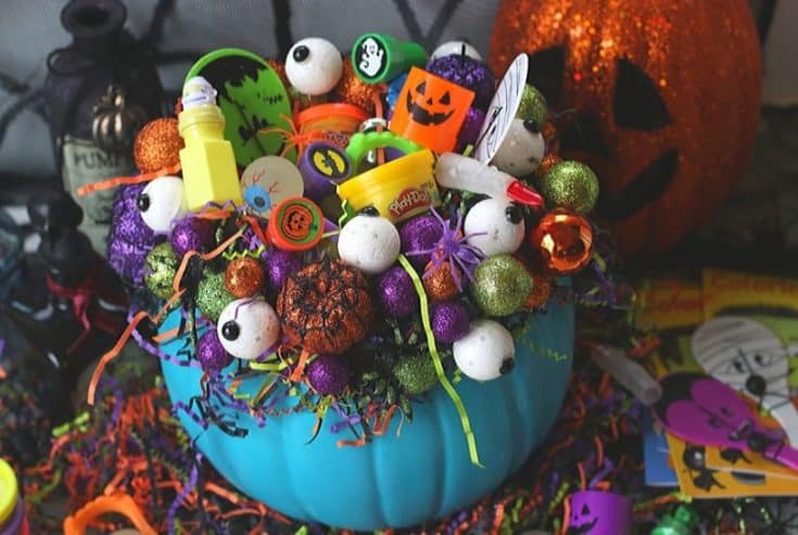 This DIY Teal Pumpkin Treat Holder is all treats and no tricks. Trick or Treaters will love this teal pumpkin filled with non-candy treats. This Halloween craft project is made using a craft pumpkin, styrofoam balls and crinkle paper. It's a perfect way to provide allergy-friendly treats to your little ghouls and goblins. #tealpumpkin #halloweencraft #pumpkincarving