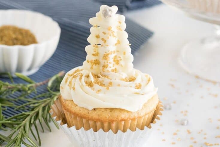 Satisfy your yuletide sweet tooth with these elegant Christmas Tree Cupcakes. This easy Christmas dessert recipe is perfect for your holiday spread. White Chocolate and pretzel sticks make the pretty glittering Christmas tree topper. #christmascupcake #cupcakerecipe #dessert