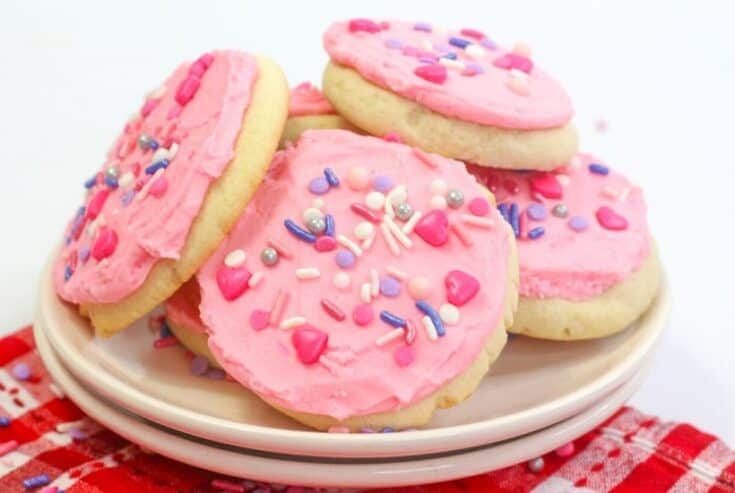These soft and buttery Valentine Lofthouse Sugar Cookies are the perfect sweet treat. These sour cream cookies are topped with sweet frosting and sprinkles. This is an easy sugar cookie recipe that requires no rolling. You can make them for any season or holiday by just changing the color of the frosting. #sugarcookies #lofthousecookies #valentinesdayrecipe #partyidea