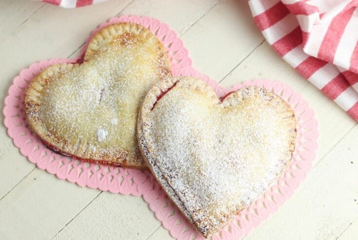 These Heart-Shaped Cherry Hand Pies are the perfect snack. Each hand pie is filled with sweet cherry pie filling sandwiched in between a flaky pie crust, then baked to perfection.
