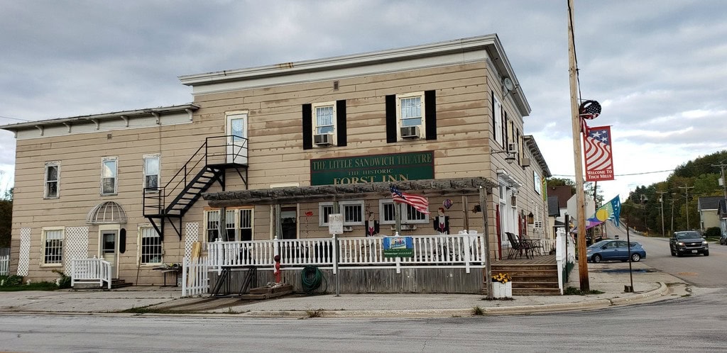 Exterior of 2-story historic building with porch lining two sides