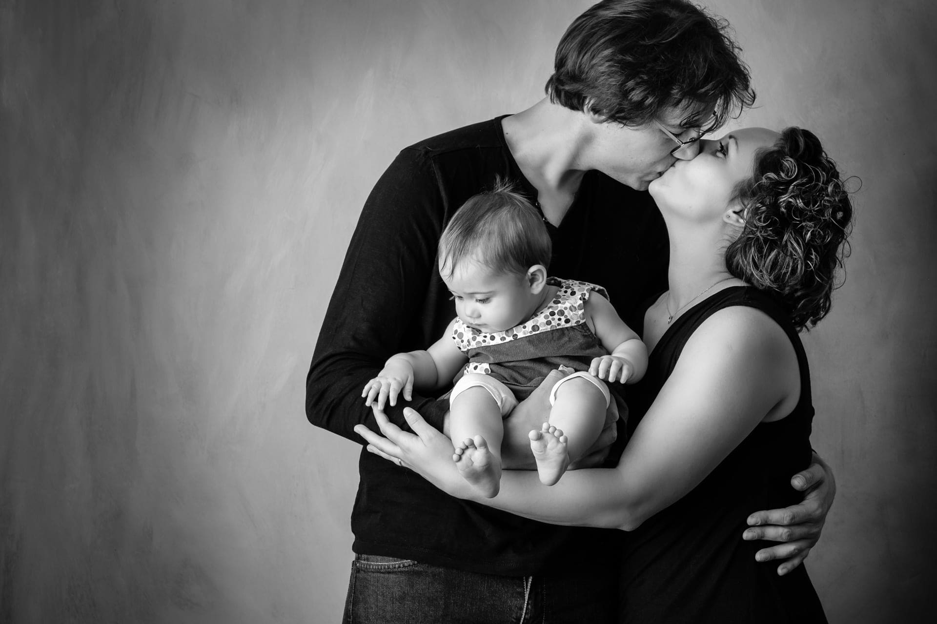Bébé dans bras des parents en noir et blanc