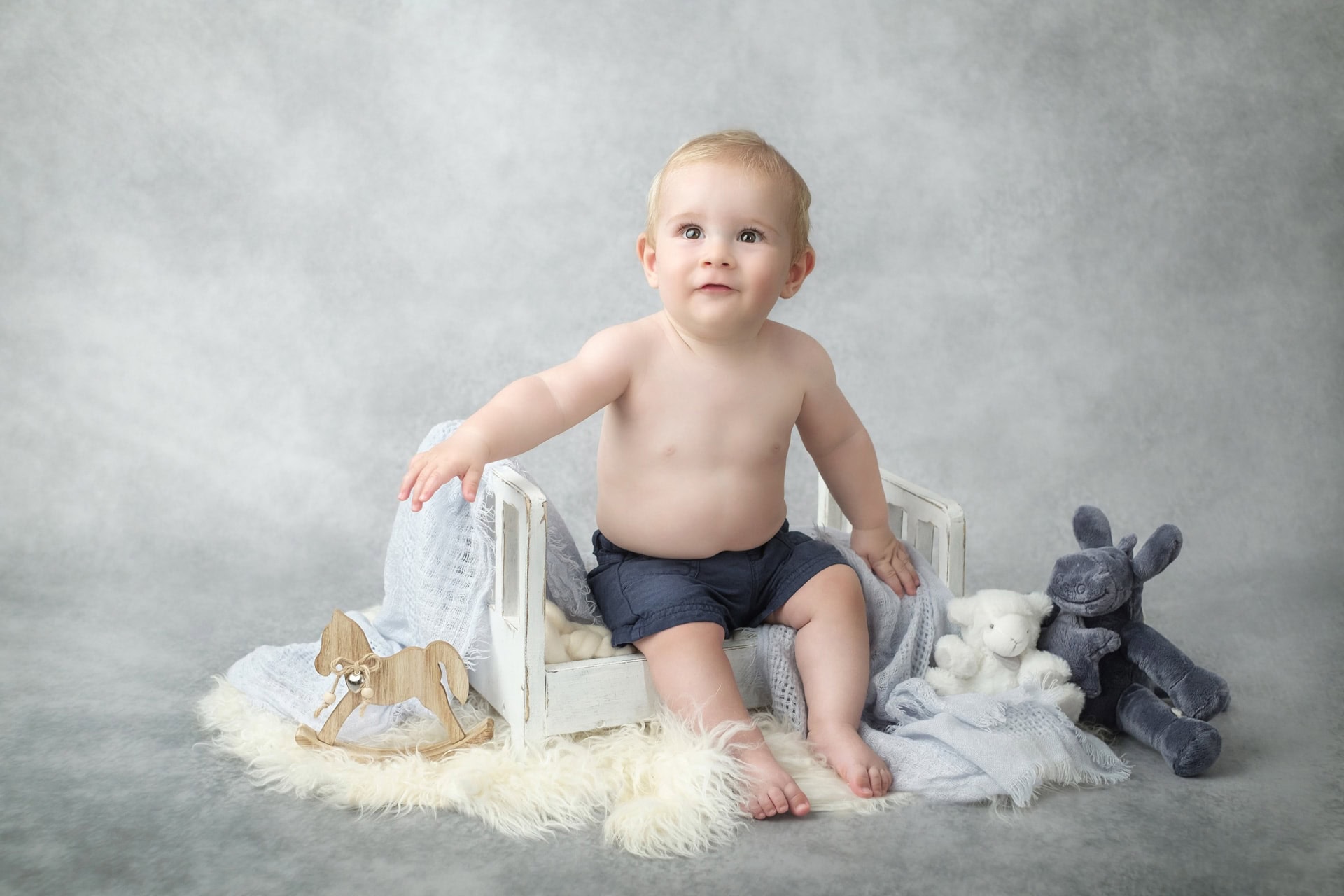 Portrait bébé avec lit en bois et peluche
