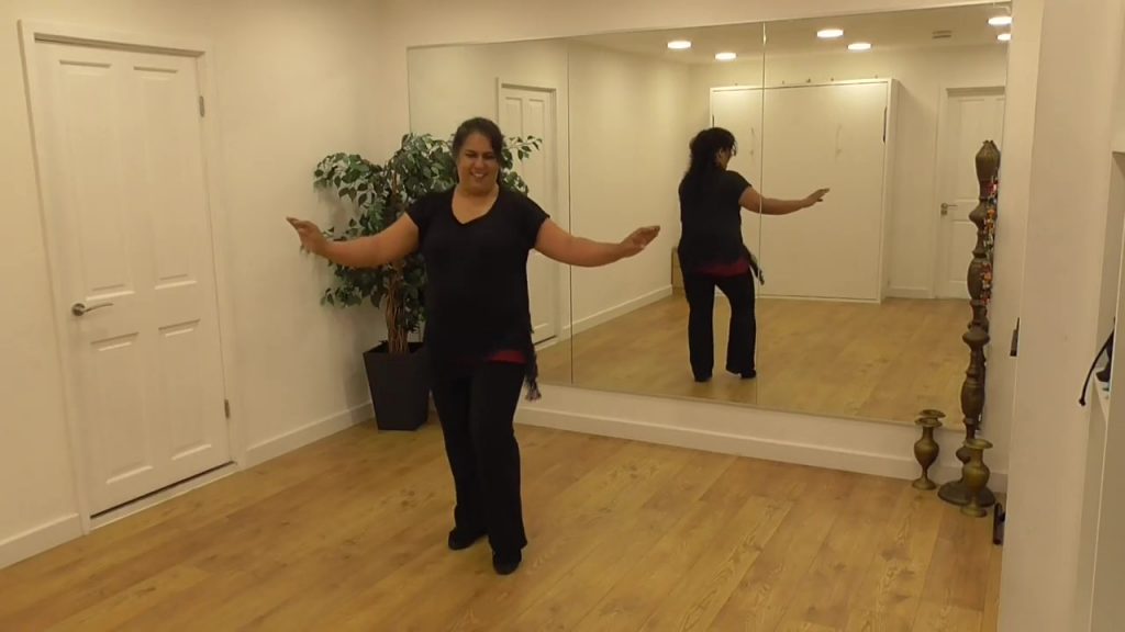 Dancer, Nisha, smiles with her arms out to the sides for darts in Doncaster Dance On