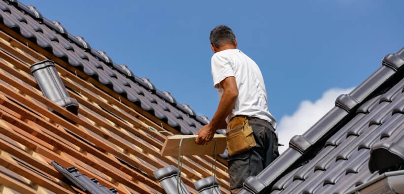 Dachdecker beim Verlegen der Dacheindeckung