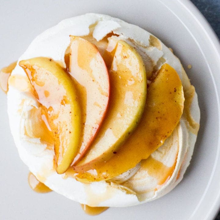 Close-up of one mini pavlova with sliced apples and caramel.