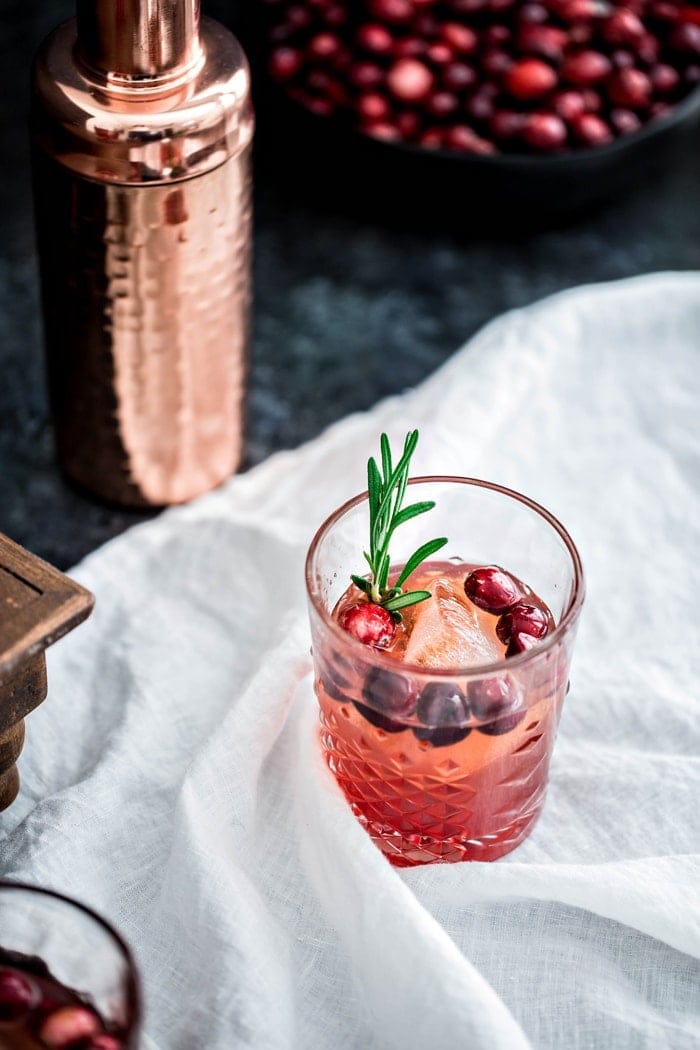This Cranberry Rosemary Shrub Cocktail is the perfect Thanksgiving cocktail! A homemade cranberry shrub with hints of black pepper, rosemary, and cinnamon is combined with bourbon and seltzer for a festive and colorful drink.
