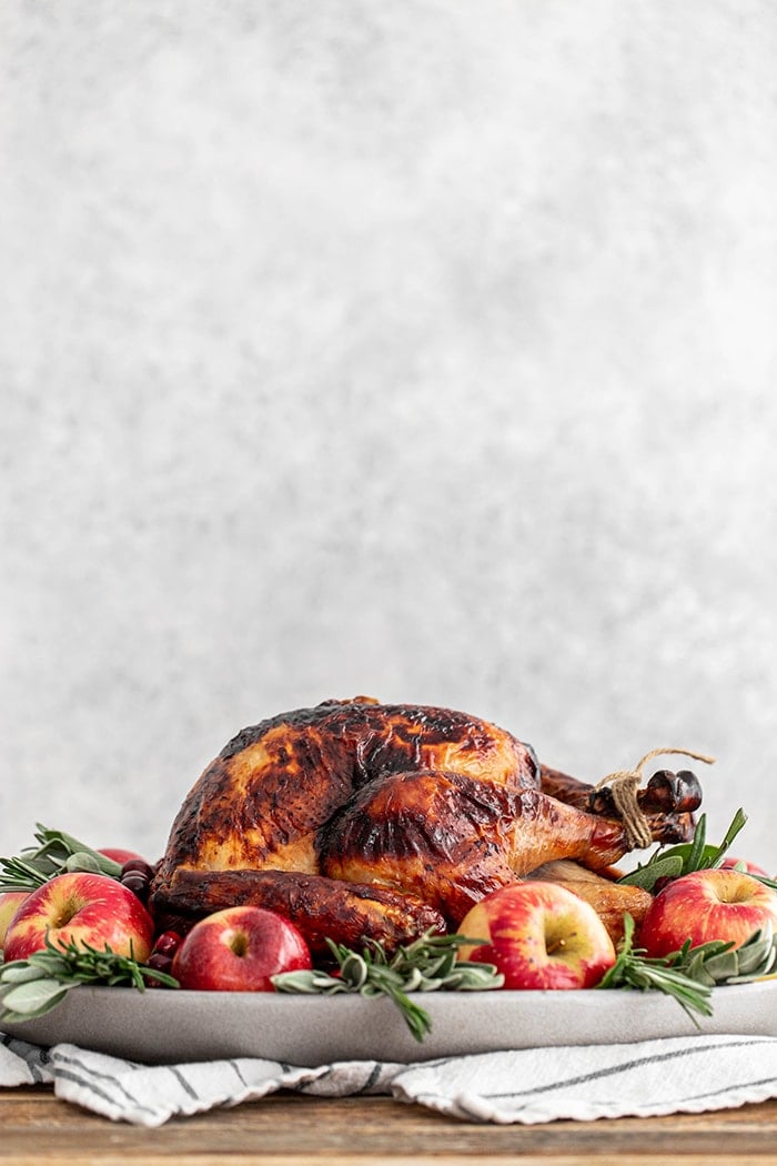 turkey on a platter with apples and sage