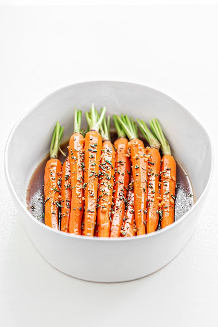 whole carrots in a white bowl