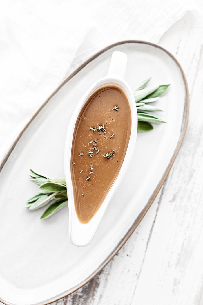 turkey gravy with sage in a white gravy boat